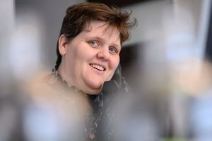 lachende dame op de werkvloer bij een verzekeringskantoor Crelan