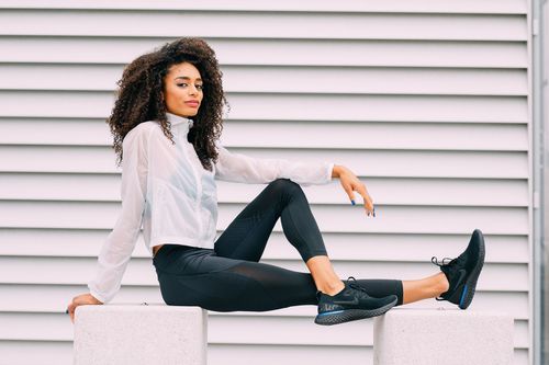 A person in a white shirt and black pants poses against a white slatted wall in multiple dynamic positions.