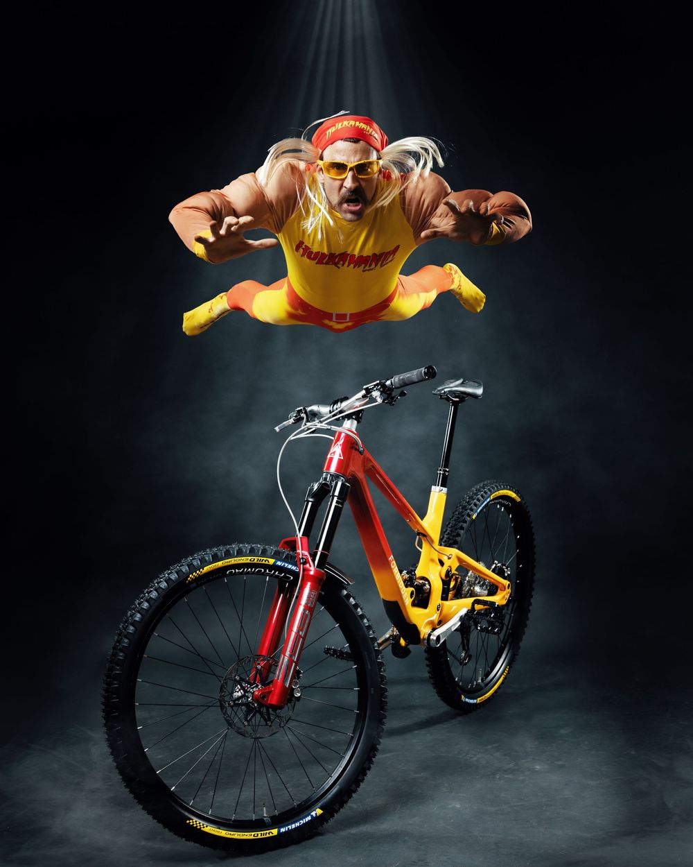 Dramatic sequence of a mountain bike performing a flip trick against a dark background with dynamic lighting effects.