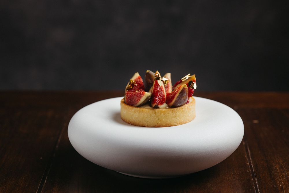 Homemade cookies with fresh strawberries and chocolate arranged on plates against a dark background.