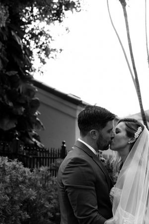 A romantic black and white photo series showing a couple sharing tender kisses on their wedding day.