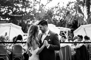 Black and white photo of wedding guests dancing at an outdoor celebration.