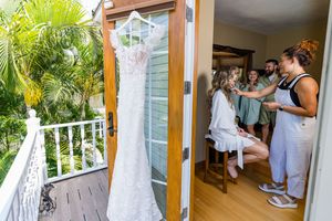Wedding party members peek through doorways and windows in a fun candid moment.