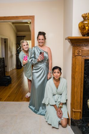 Wedding party in mint green robes relaxing during pre-ceremony preparations.