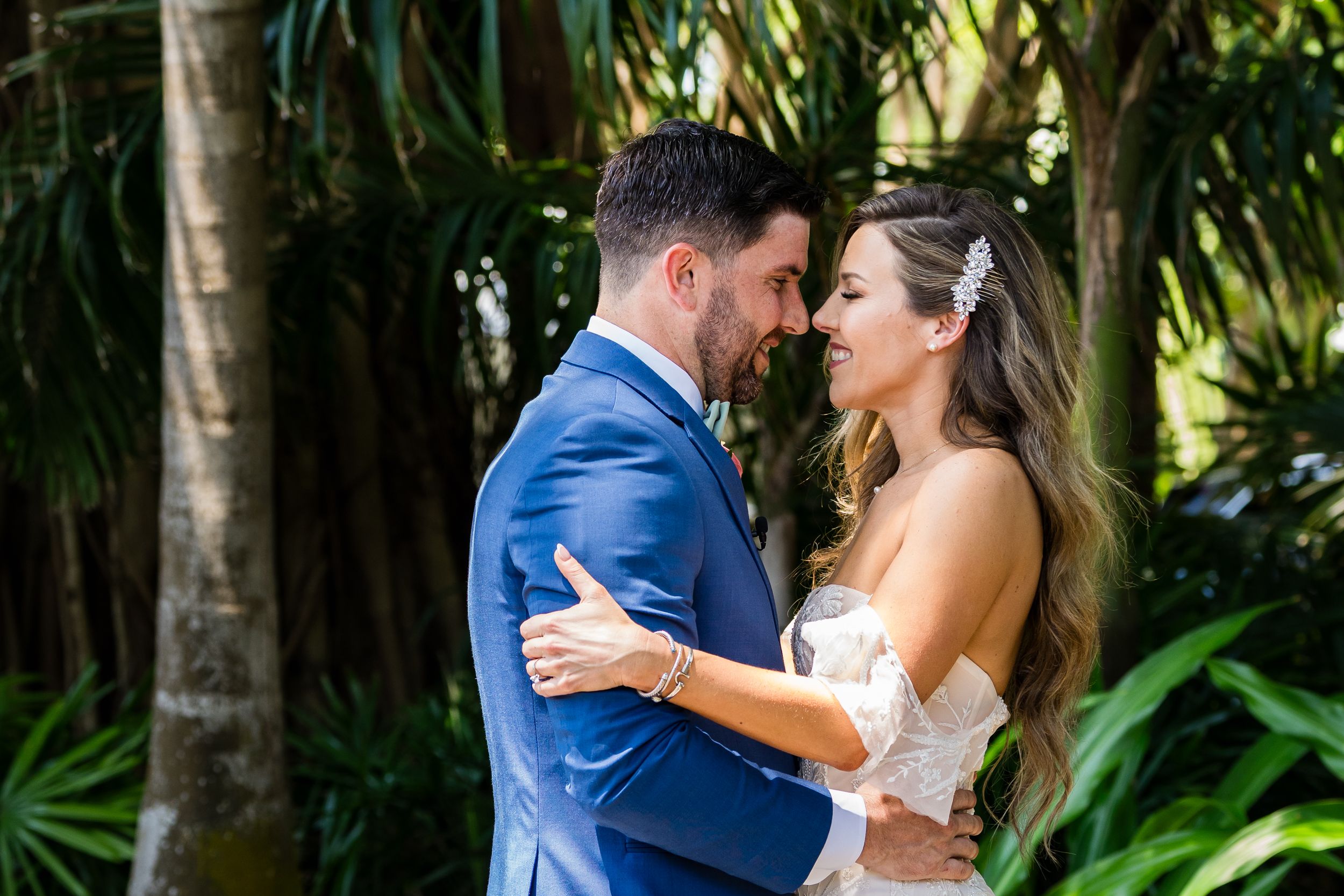 Romantic moment captured in a lush garden setting with tropical foliage.