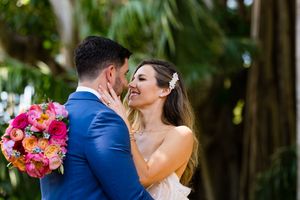 Couple sharing an intimate moment surrounded by tropical plants and bright flowers.