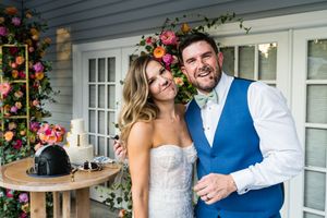 Newlyweds celebrate at outdoor reception with floral decorations and rustic table setting.