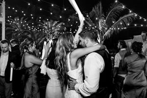 Wedding reception dance floor filled with guests celebrating under twinkling lights.