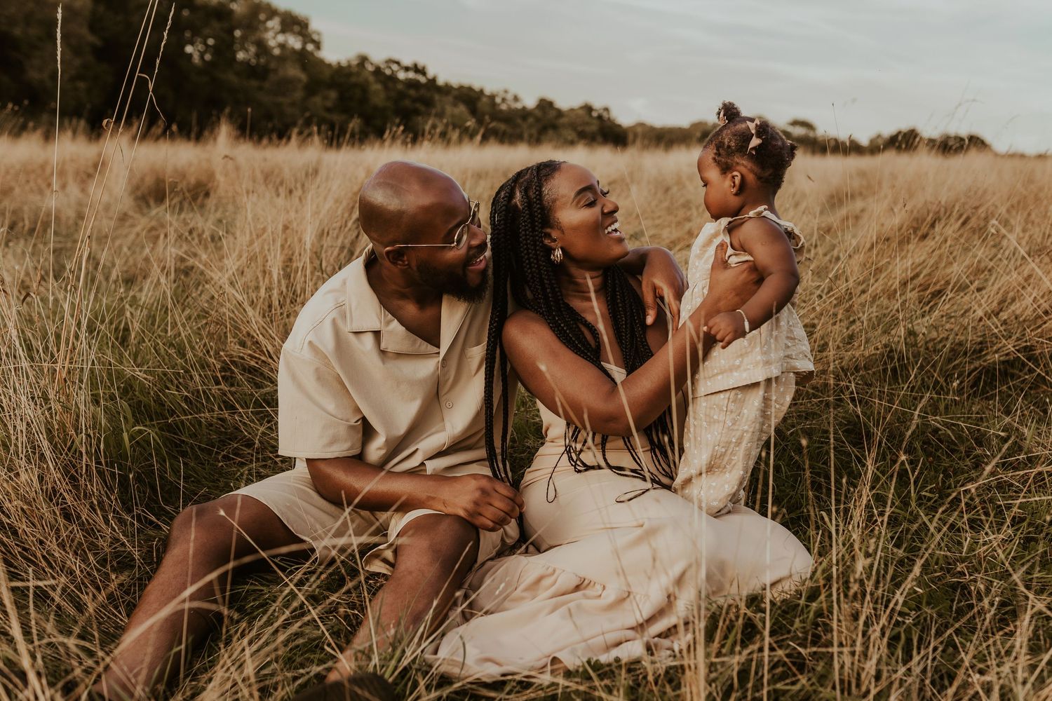 A romantic couple embraces in a golden wheat field during sunset creating an intimate outdoor family series.
