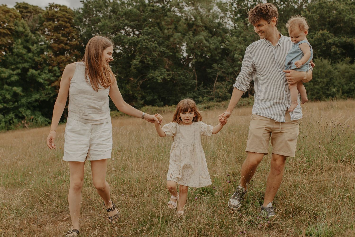 A romantic couple embraces in a golden wheat field during sunset creating an intimate outdoor family series.