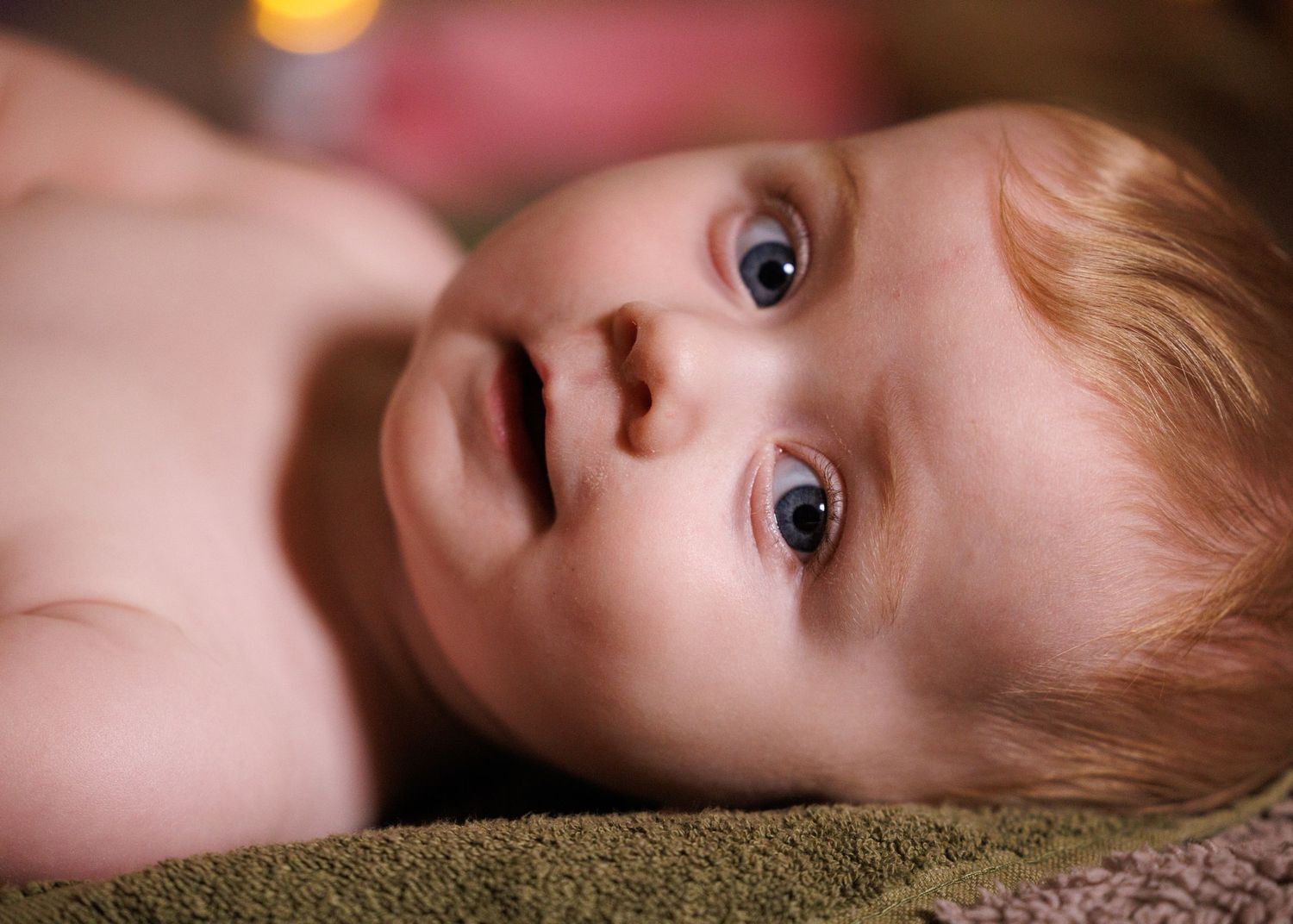 A sequence of close-up photos showing a child lying down on a textured surface in different poses.