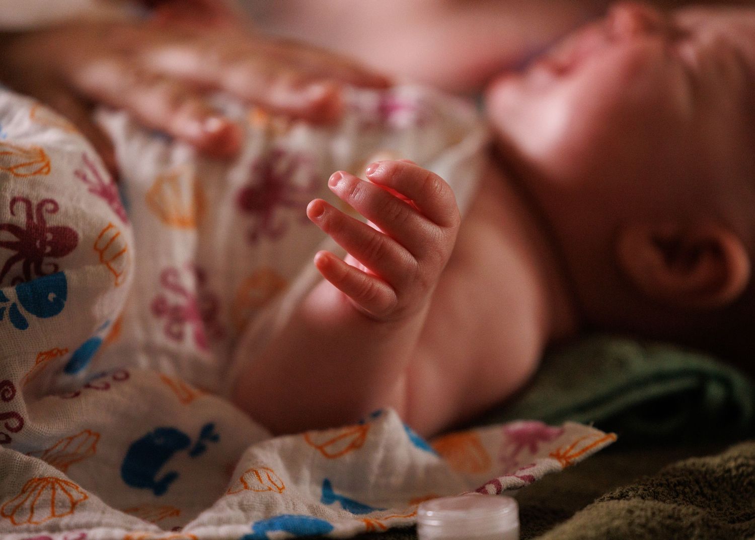 Close-up view of baby wearing diaper with whimsical sea creature patterns.