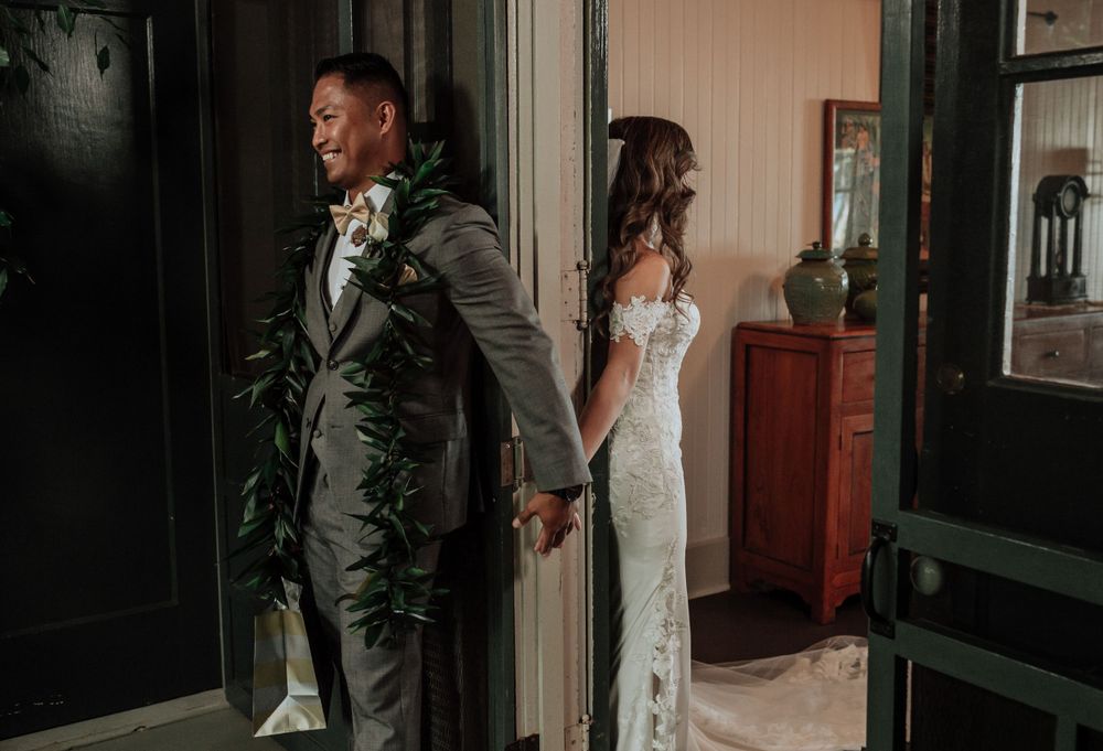 Wedding couple shares intimate moments in a dimly lit hallway with vintage decor.