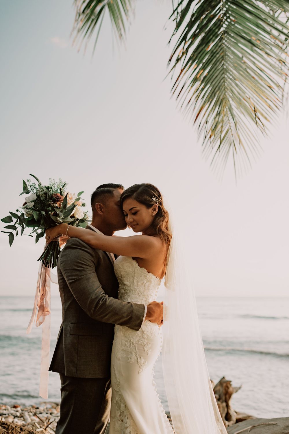 Romantic beachside moment under swaying palm trees at sunset.