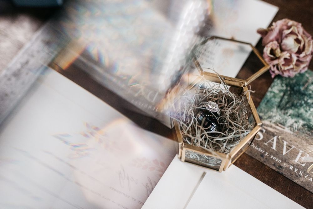 Wedding details and accessories arranged on light marble surface.