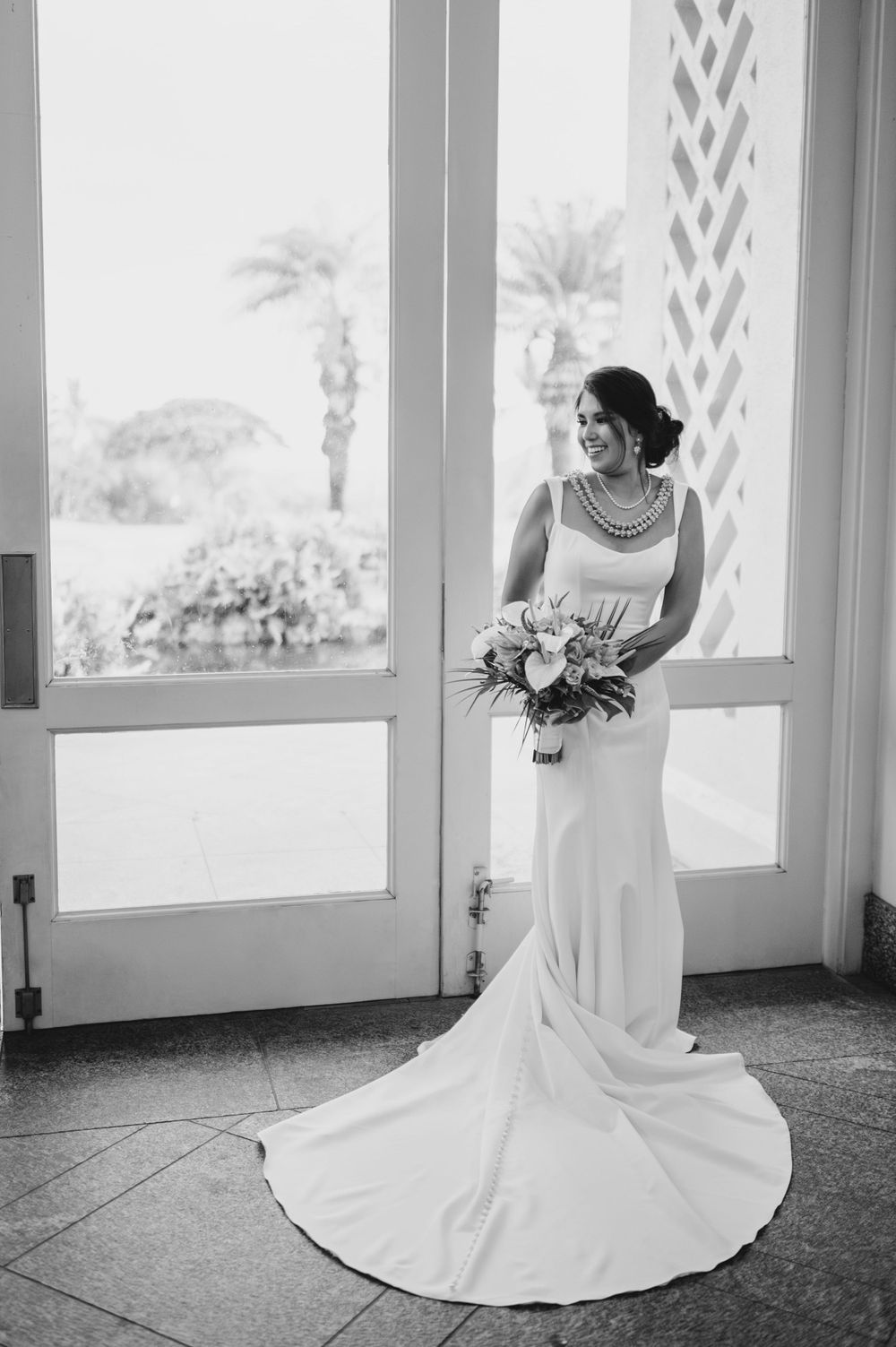Elegant bridal portraits in black and white showing a flowing wedding dress train.
