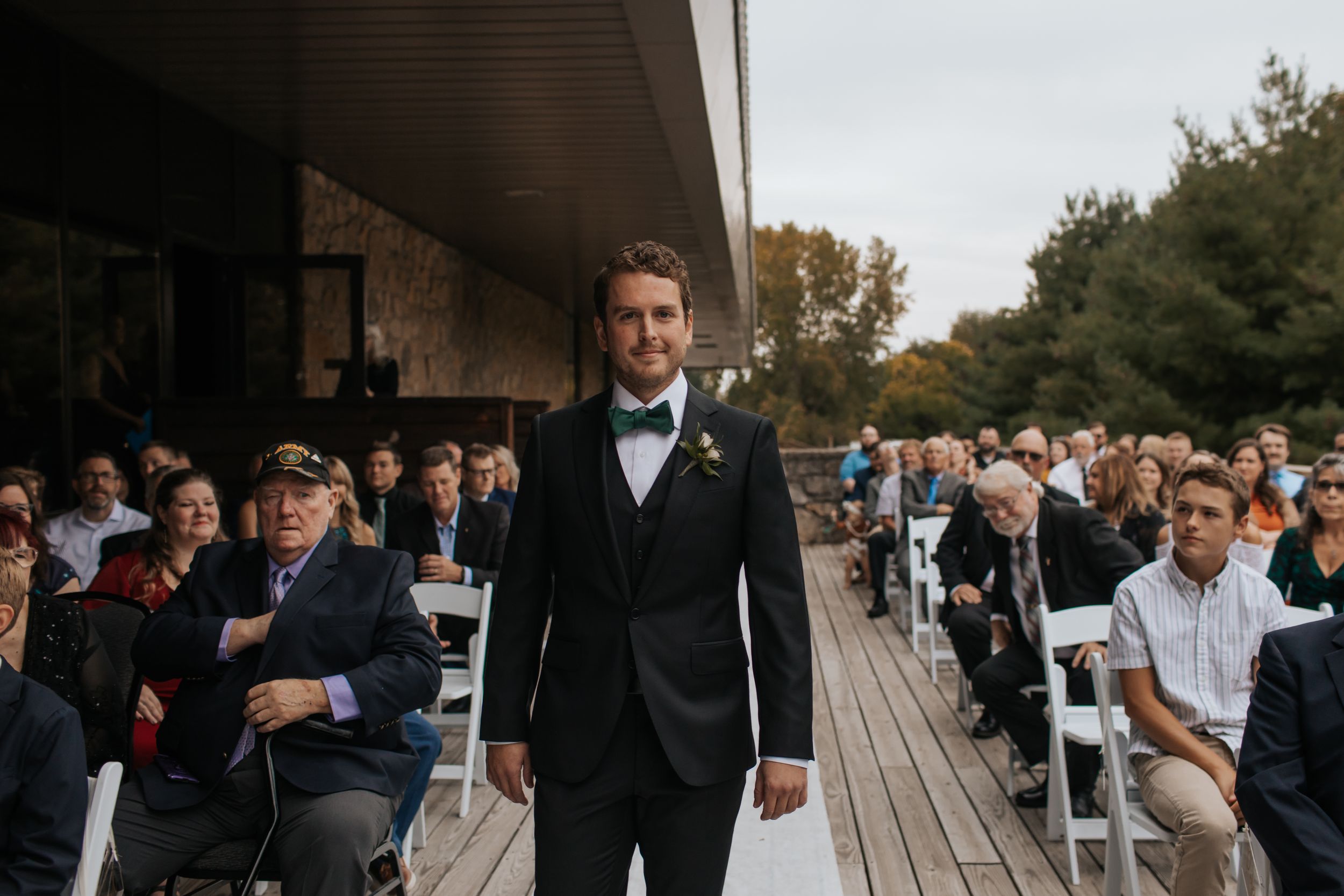 Wedding guests gather on a rustic wooden deck during an outdoor celebration at sunset. Conner Prairie, Fishers Indiana