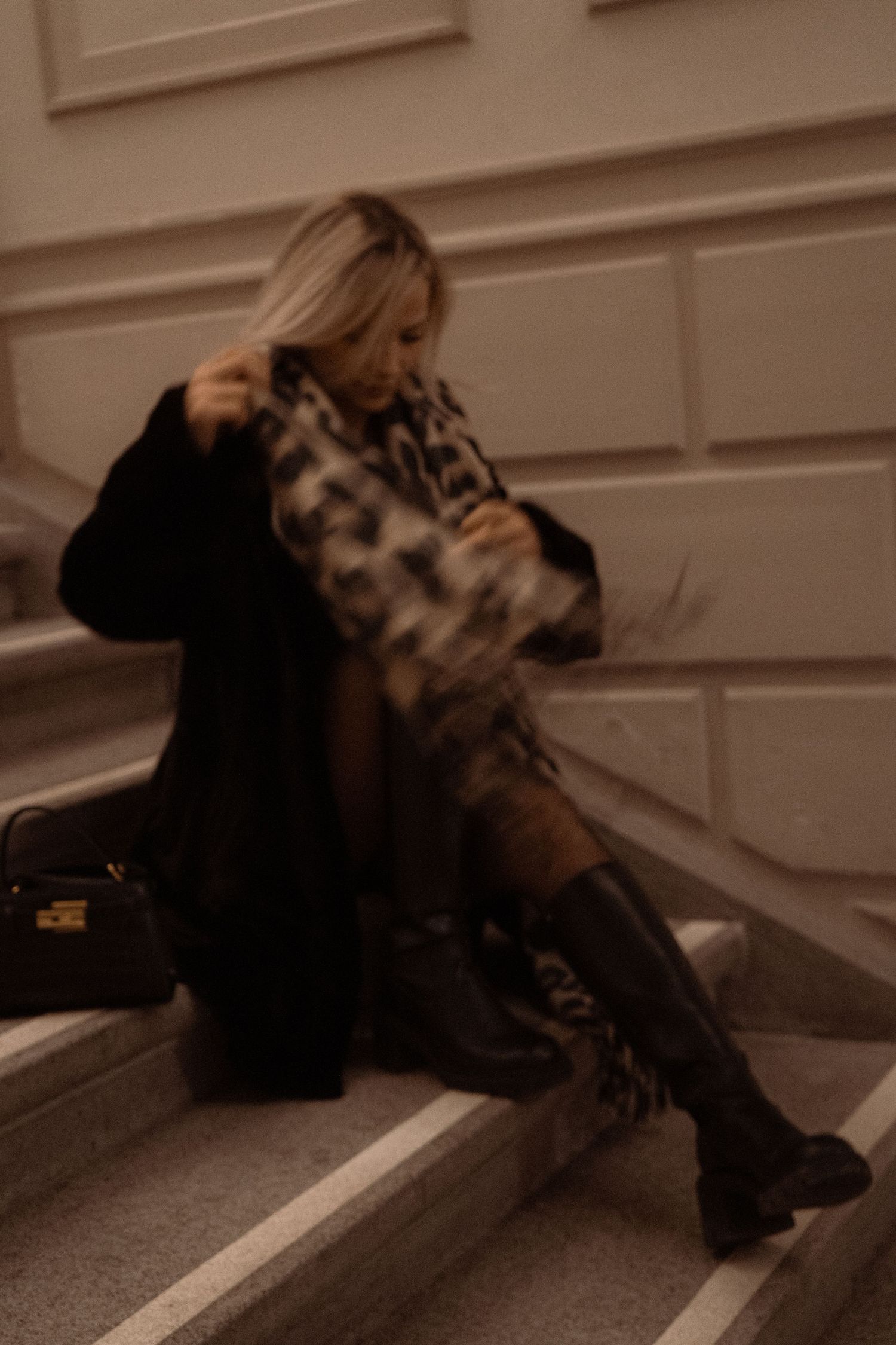 A person relaxing on a carpeted floor in dim lighting.