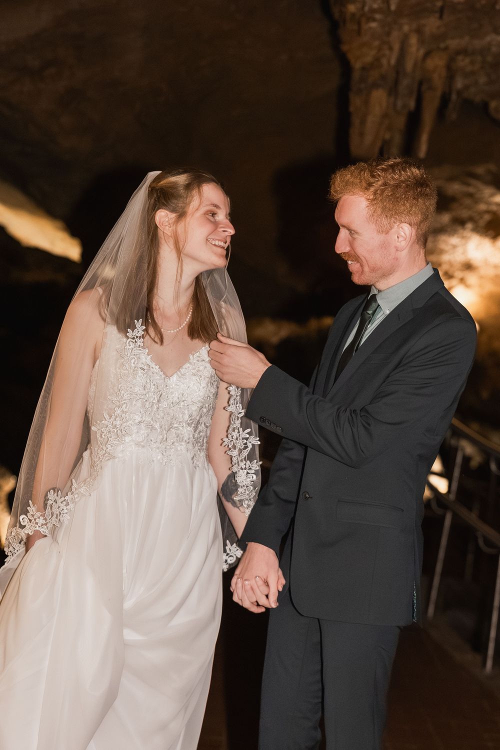 A couple shares an intimate dance moment at their wedding reception in a dimly lit venue.