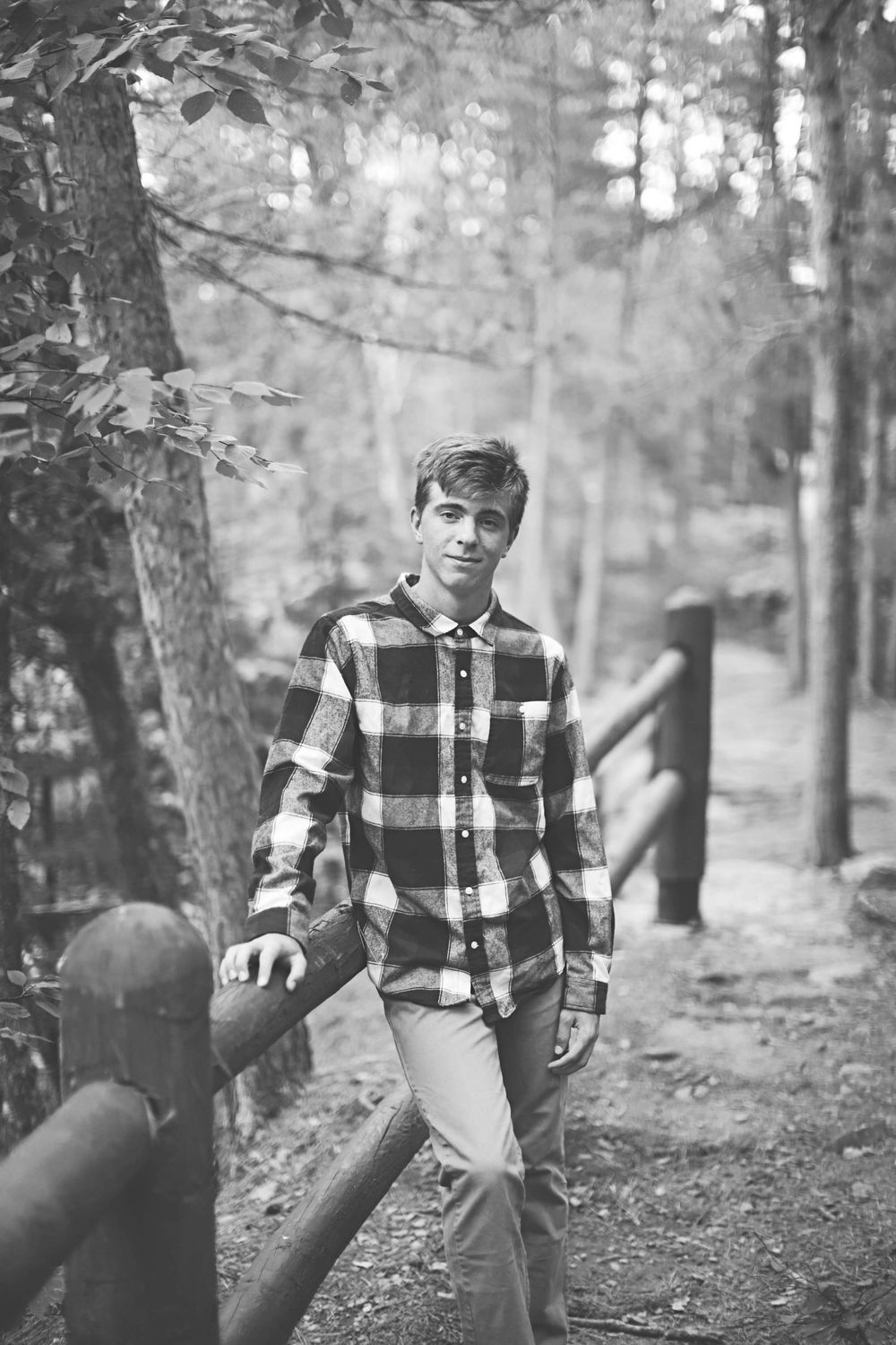 A series of black and white photos showing someone in a plaid flannel shirt walking through a misty forest setting.