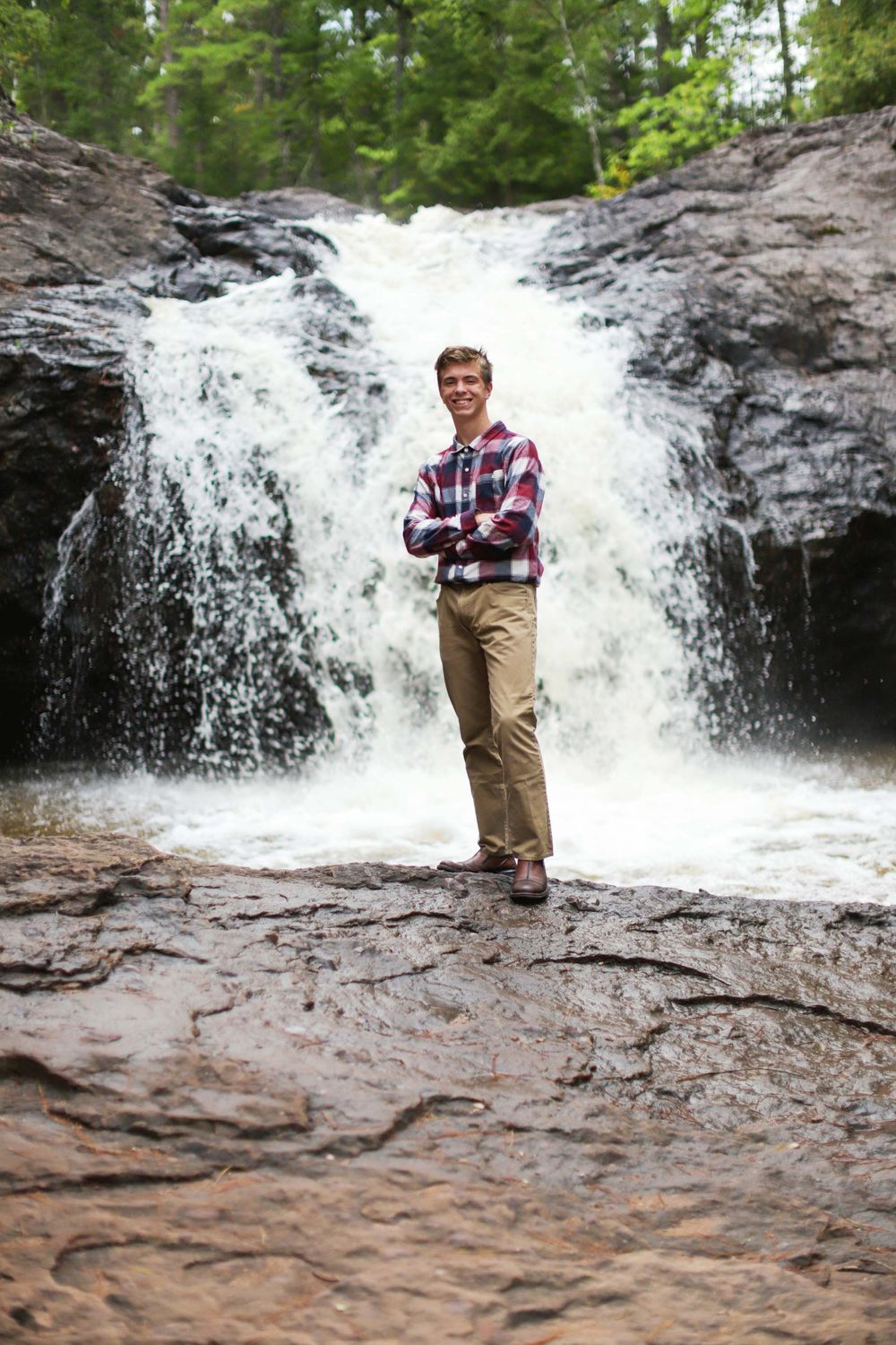 Rushing waterfall cascading over rocky terrain in a forest setting.