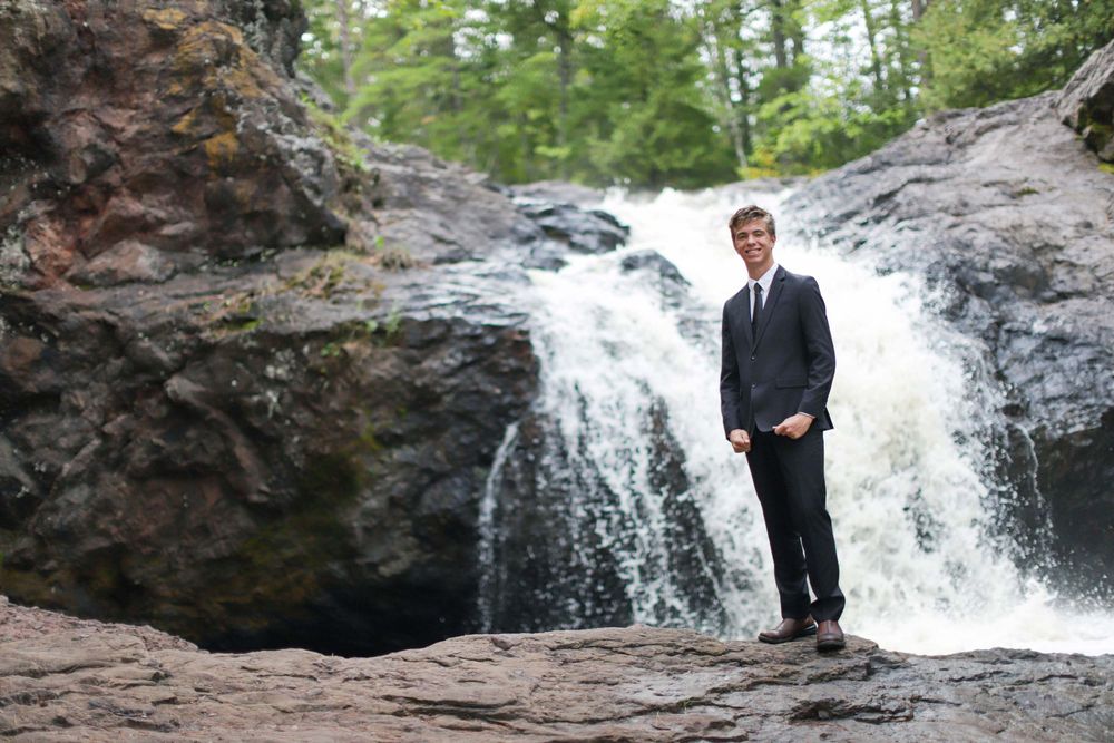 Scenic waterfall backdrop with rocky outcroppings in a forest environment.