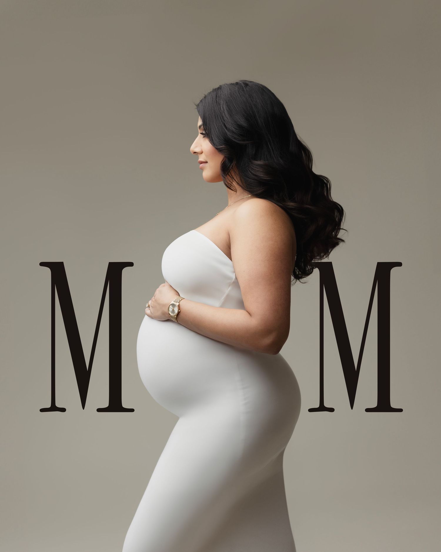 Elegant maternity portrait in white dress with M_M typography against neutral background showing side profile pose.