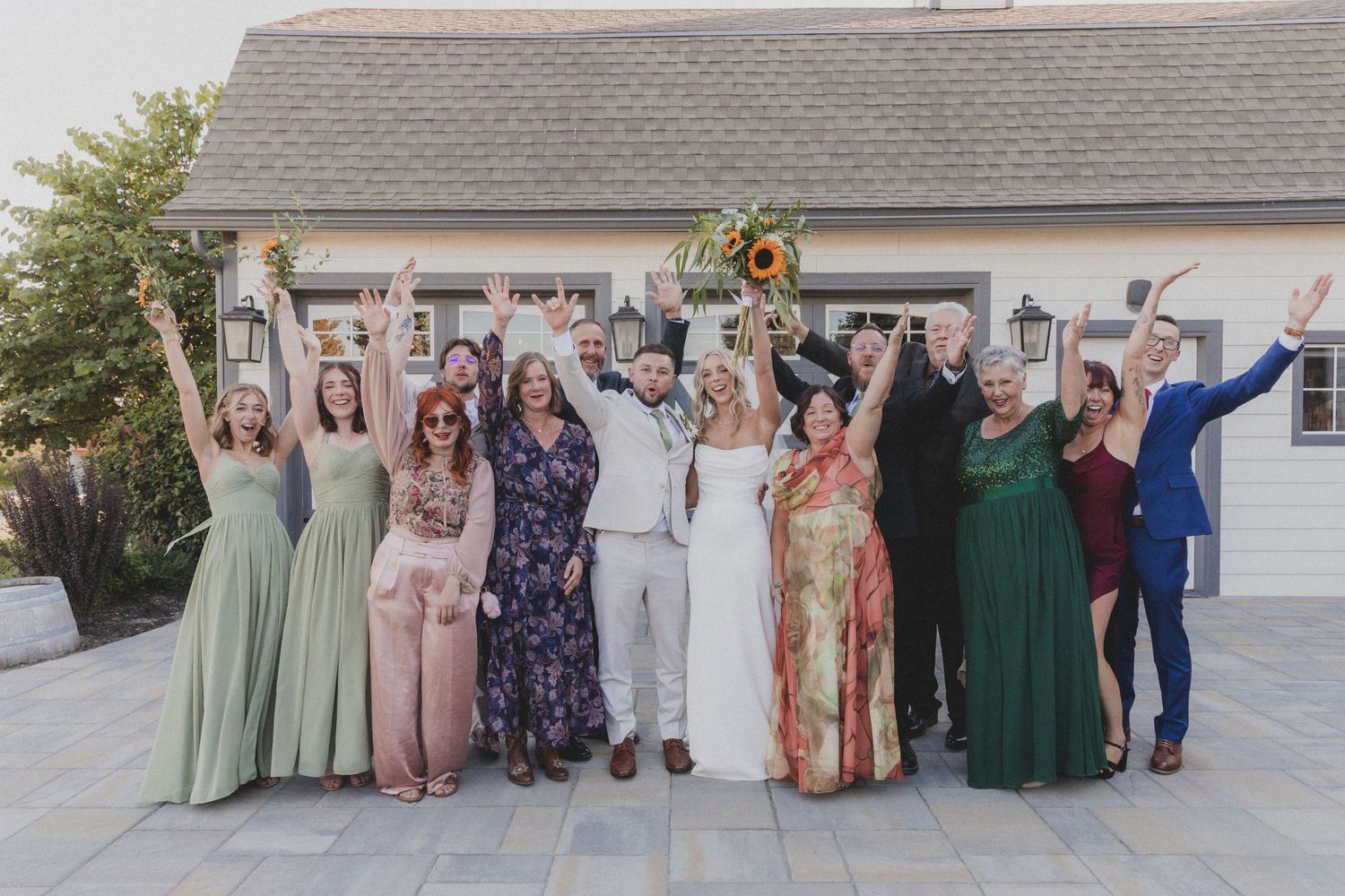 Group celebration photo outside white building with people in formal attire.