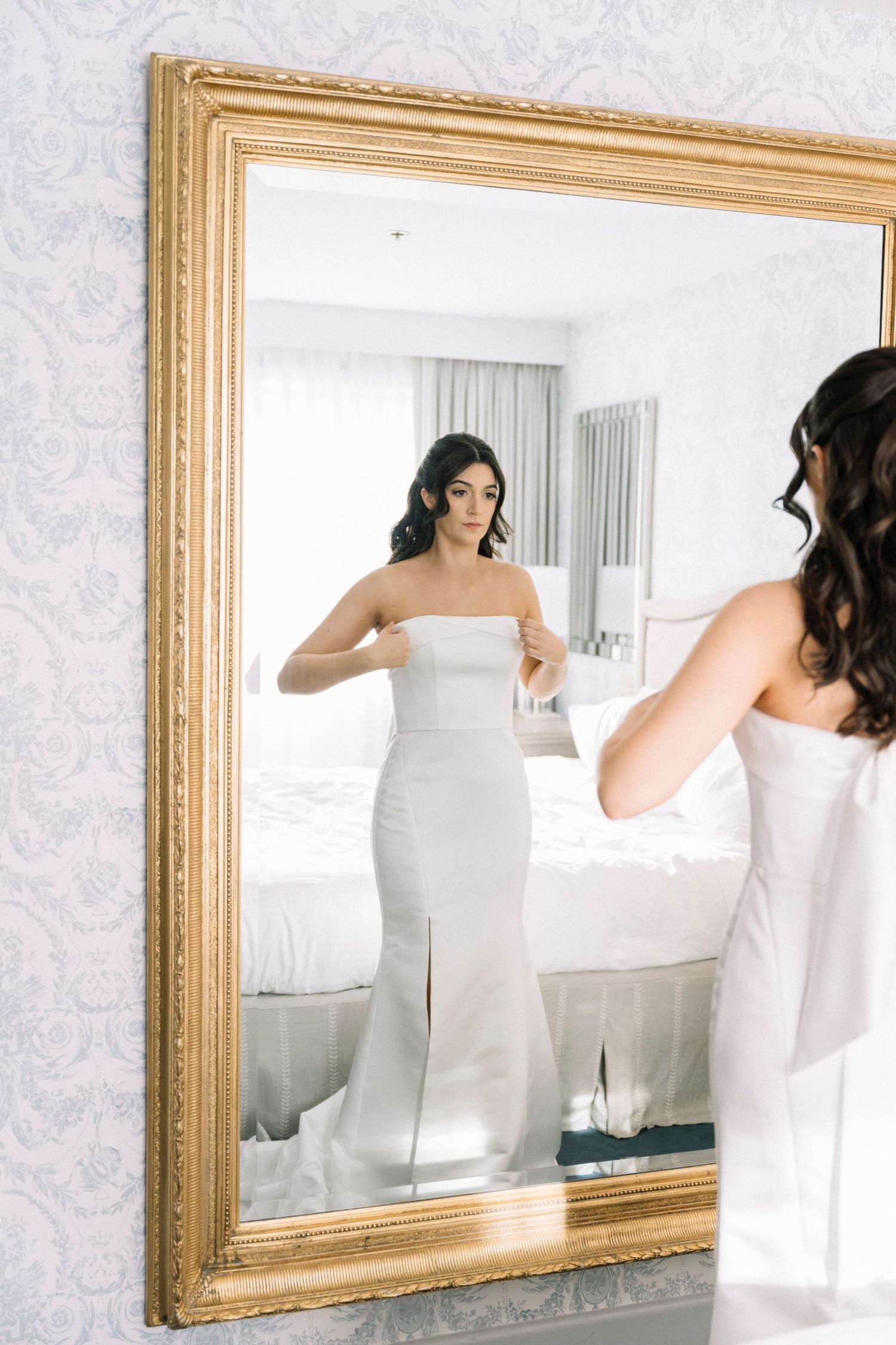 A series of mirror reflections show a person wrapped in a white towel getting ready in a bathroom.