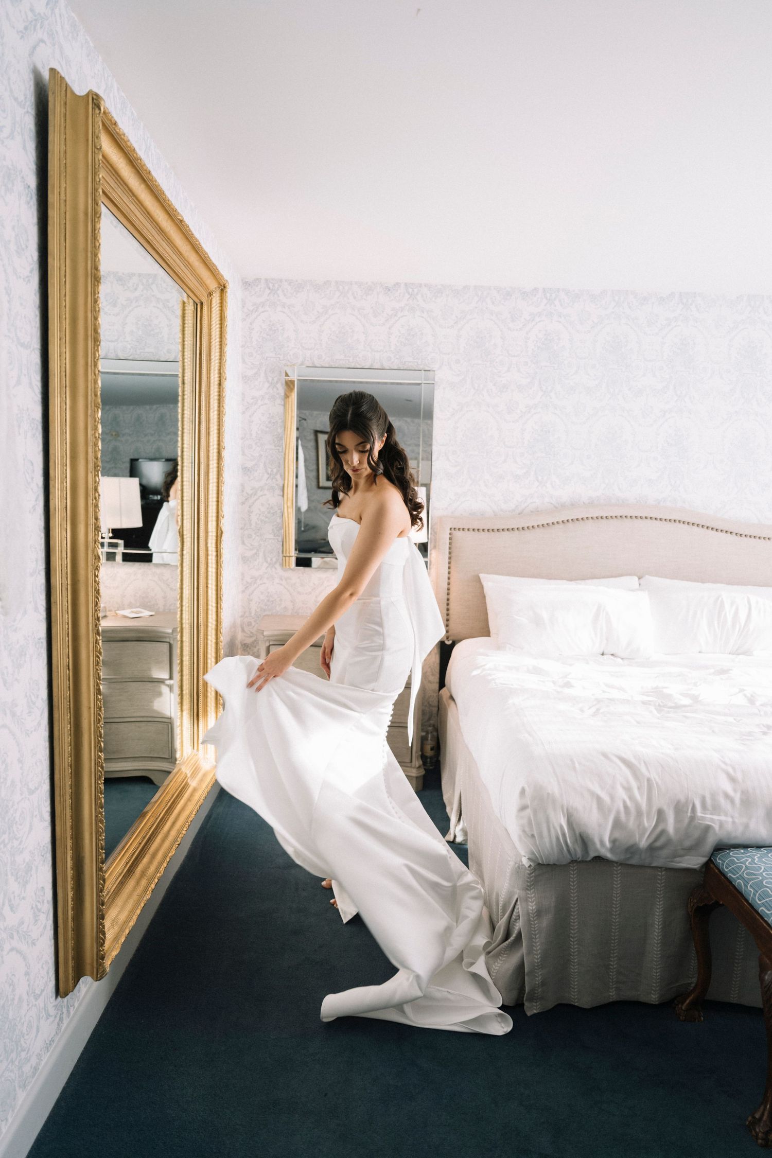 A series of artistic photos showing a white wedding dress flowing and moving against a bedroom wall with gold-framed mirror.