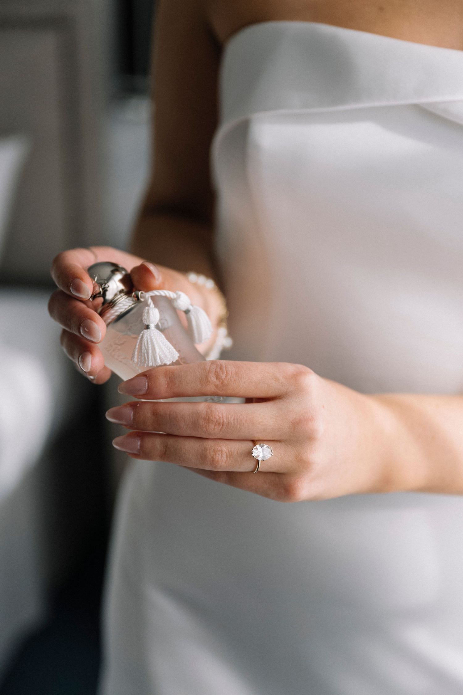 Close-up shot of hands holding delicate wedding rings with natural lighting.