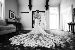 A black and white photo series showing the dramatic spread of a wedding dress train across a hardwood floor.