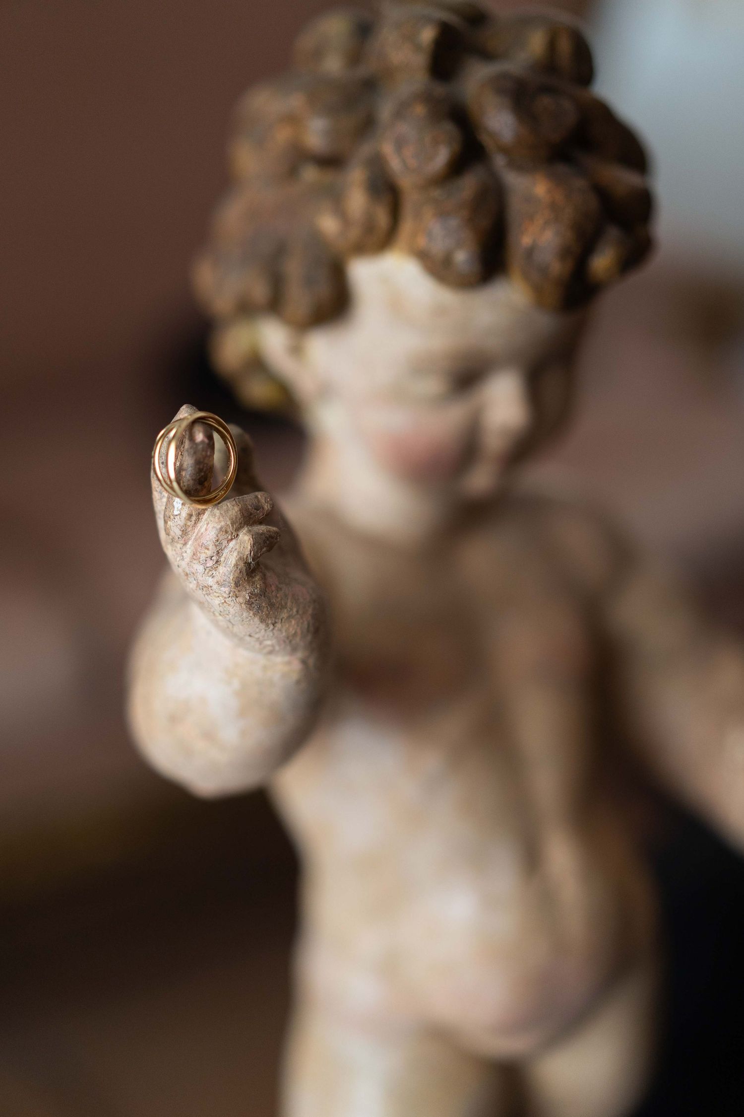 Close-up details of vintage cherub decorative figurines with soft brown patina finish.