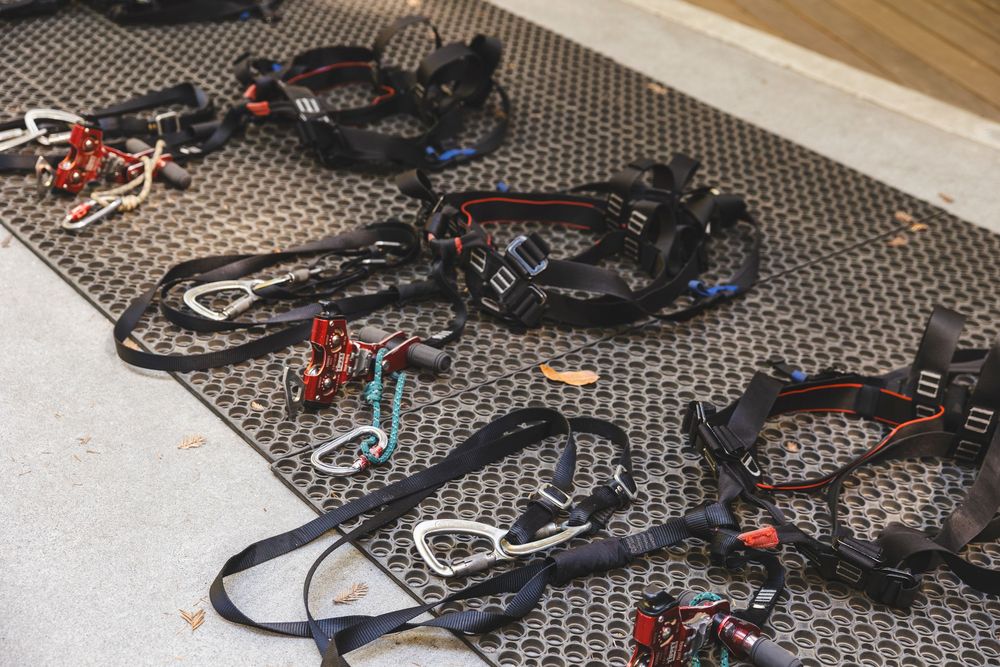 Multiple black electronic devices and cables arranged on a textured gray surface with red accents visible.