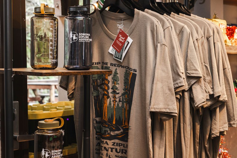 Retail clothing store interior with racks of beige and neutral colored garments displayed on hangers and shelves.