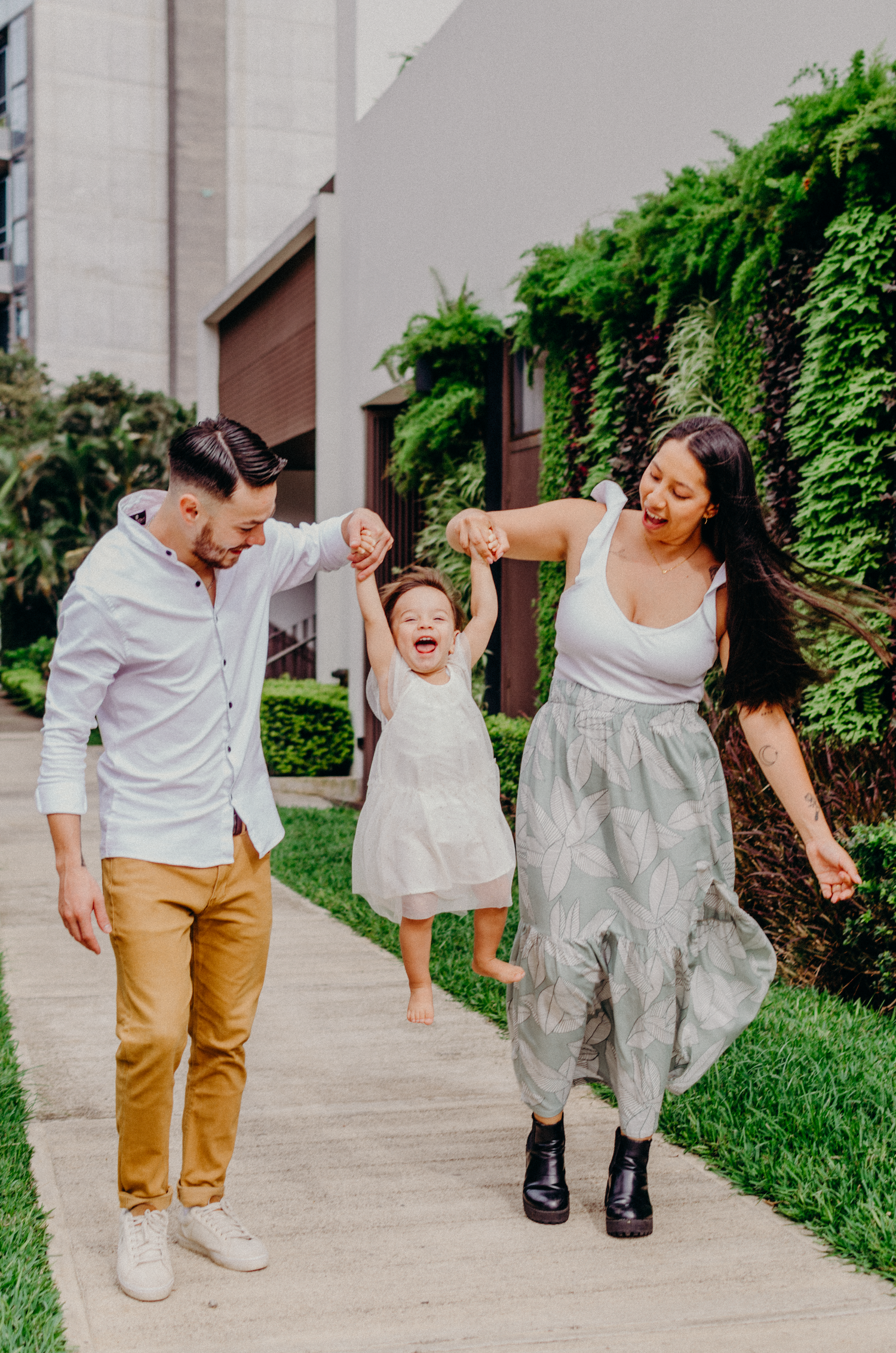 Joyful moment on sidewalk with greenery backdrop.