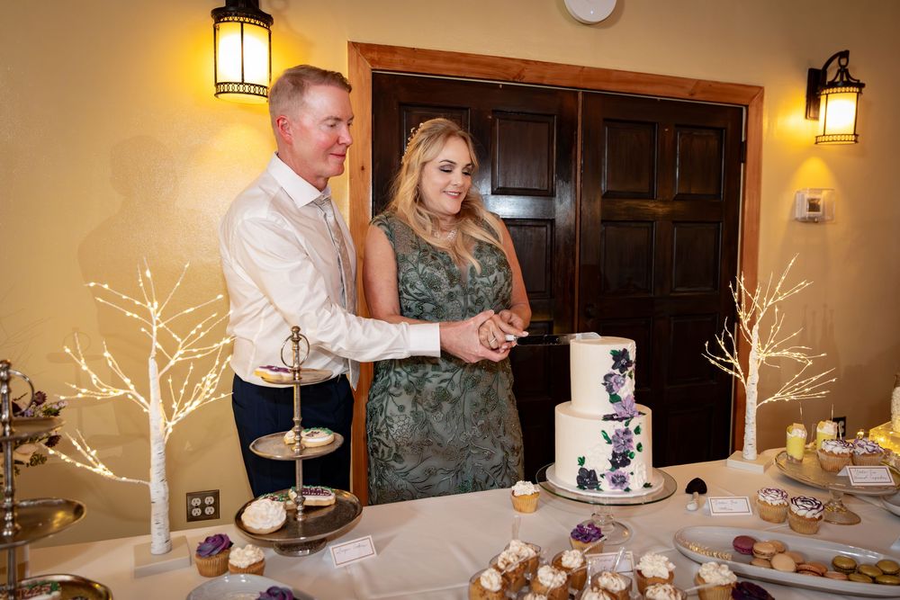 Illuminated lantern sconces and decorative white branch centerpieces adorn a wedding reception venue setup.