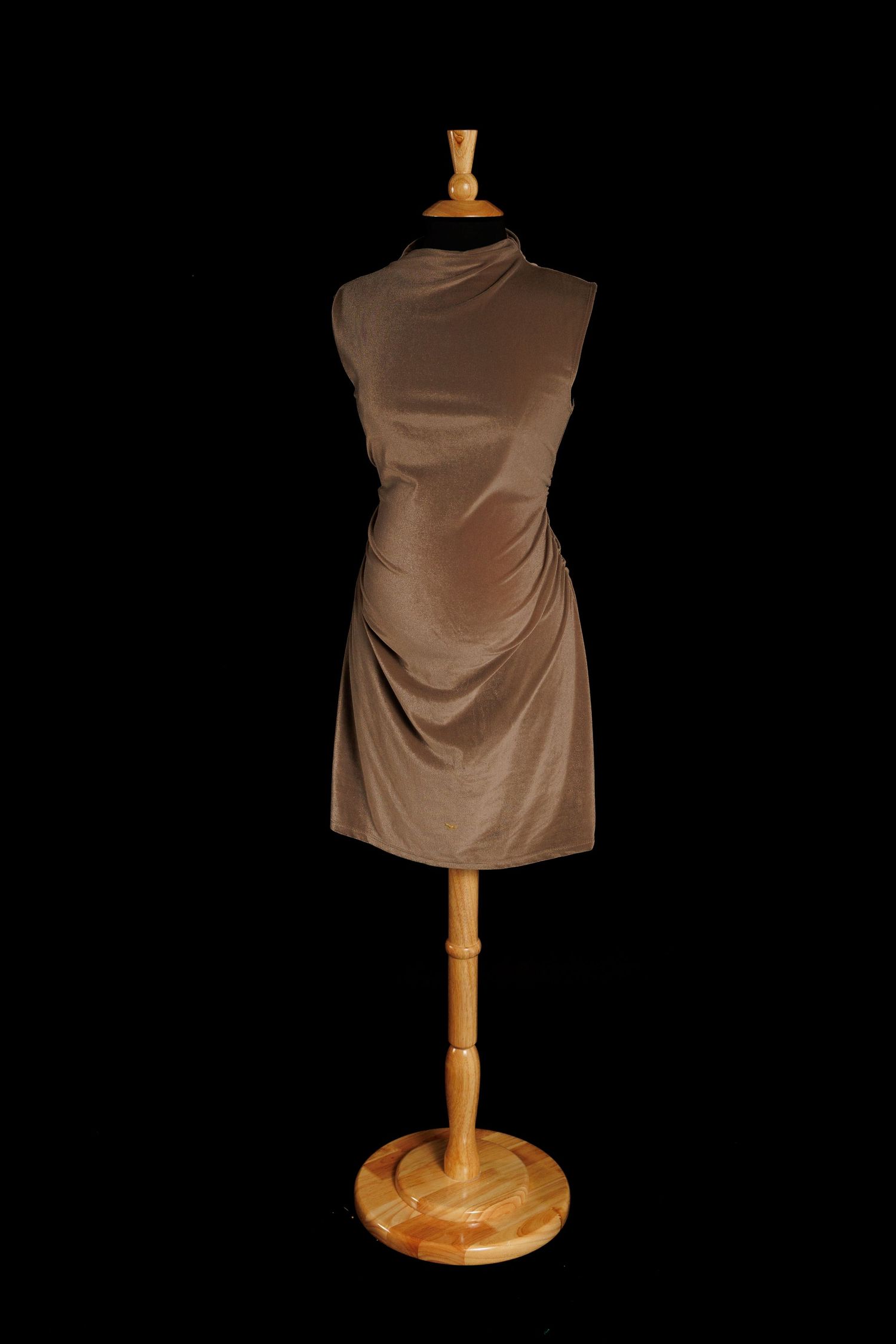 Taupe sleeveless maternity mini dress with soft draping and minimalist silhouette on mannequin