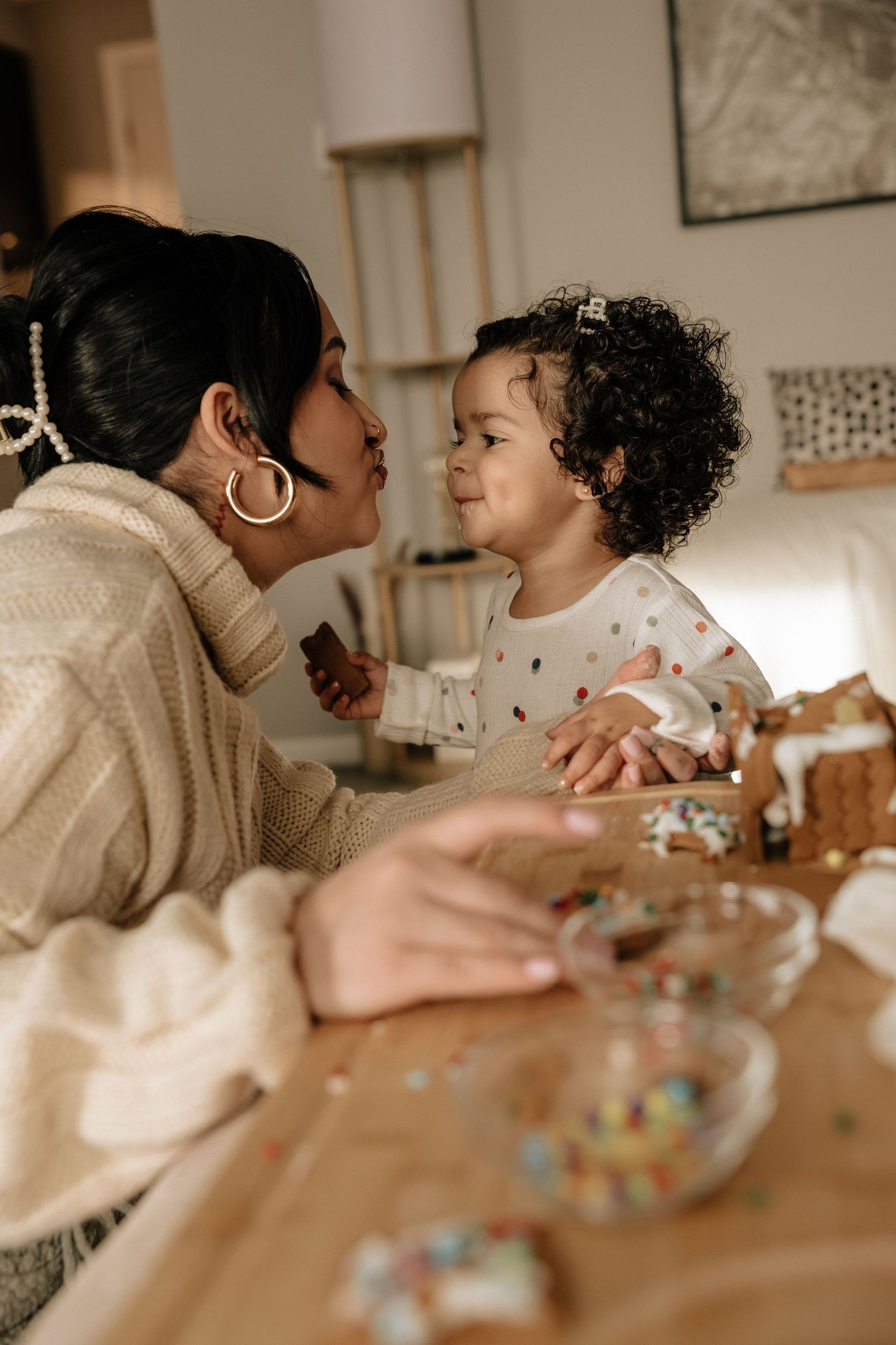 A tender moment between parent and child during a creative activity at a wooden table.