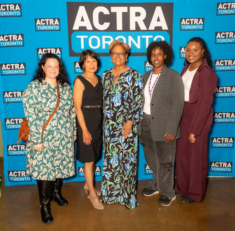A group of five people pose together at an ACTRA Toronto event against a blue branded backdrop.