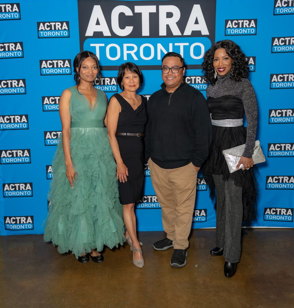 Four people stand together at an ACTRA Toronto event in formal attire against a blue step-and-repeat background.