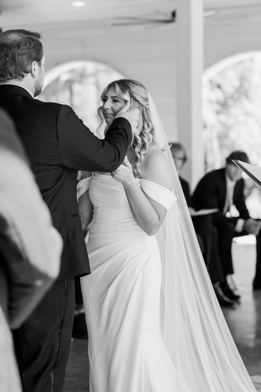 A tender wedding first look moment captured in black and white photography.