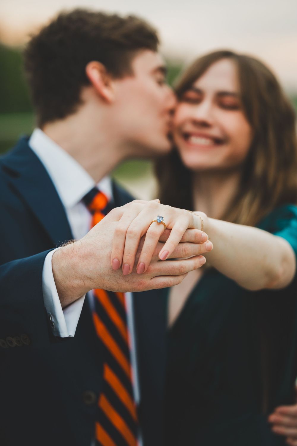 Close-up series of hands showing a couple's romantic engagement moment with an orange striped tie visible in the background.