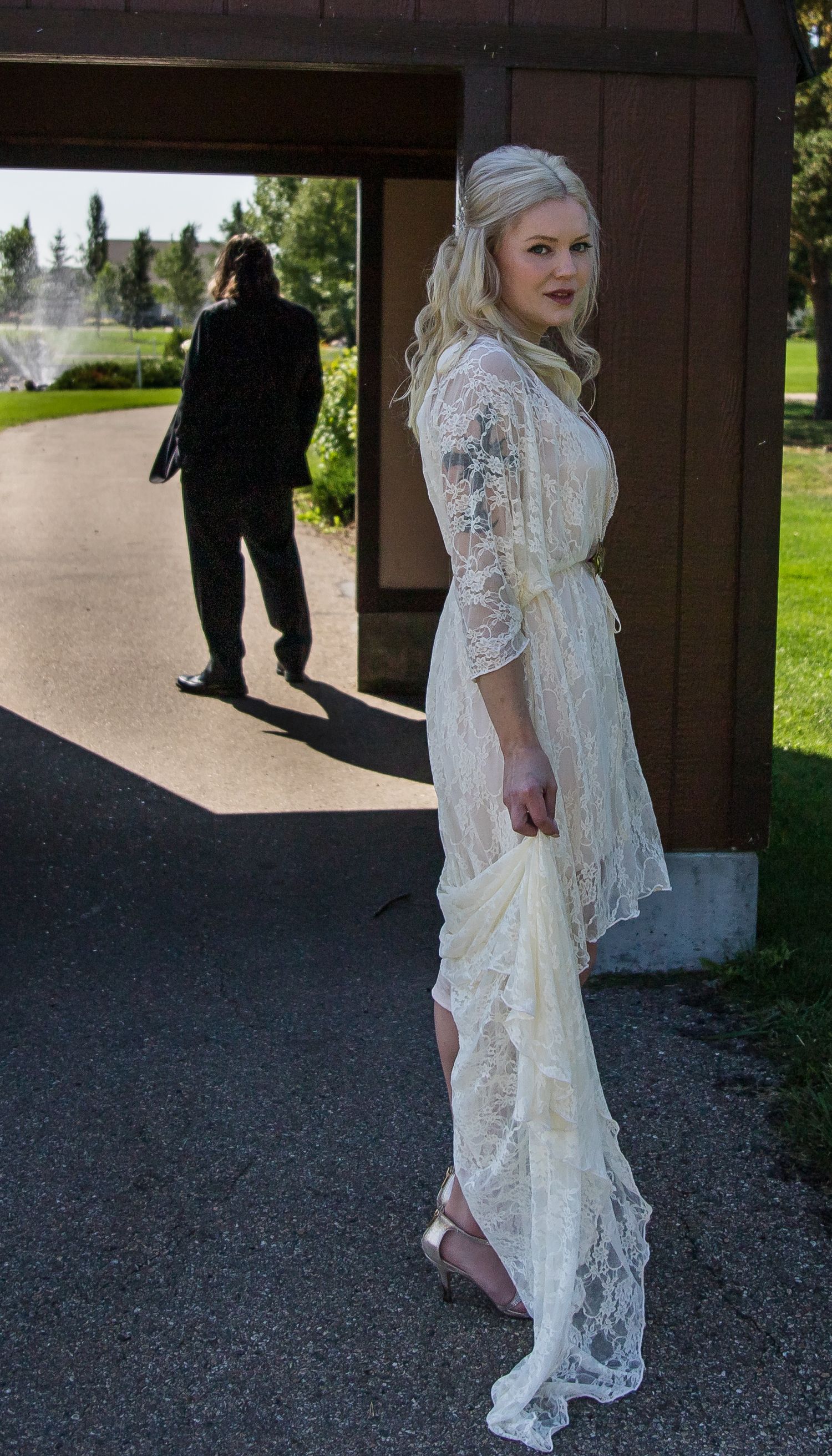 A sequence of photos showing a person in an elegant white lace dress walking along a gravel path outdoors.