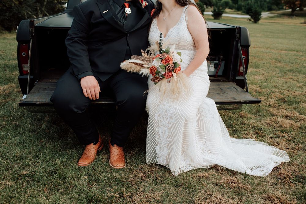 Couple celebrating western-themed wedding at rustic barn in Tennessee with vintage truck