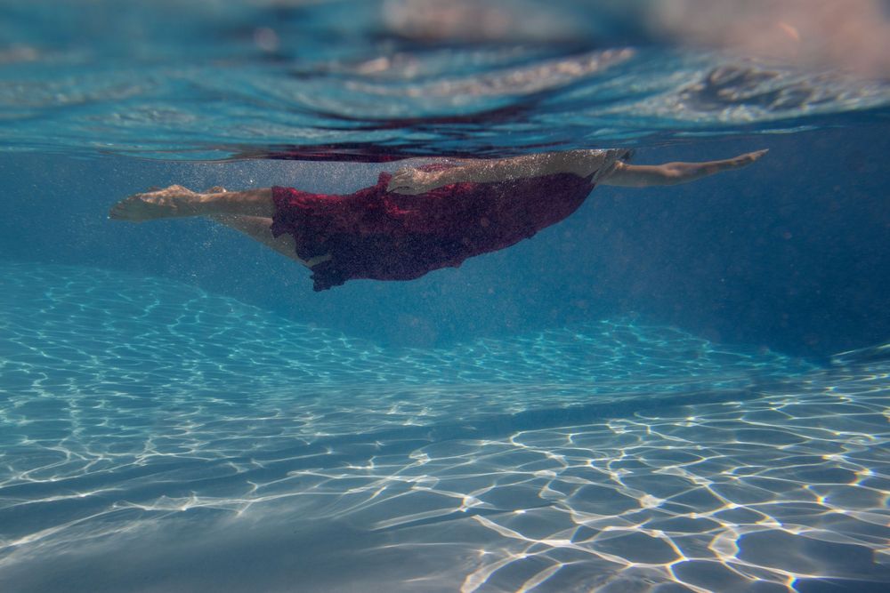 Underwater sequence showing rippling patterns of sunlight through crystal clear pool water.