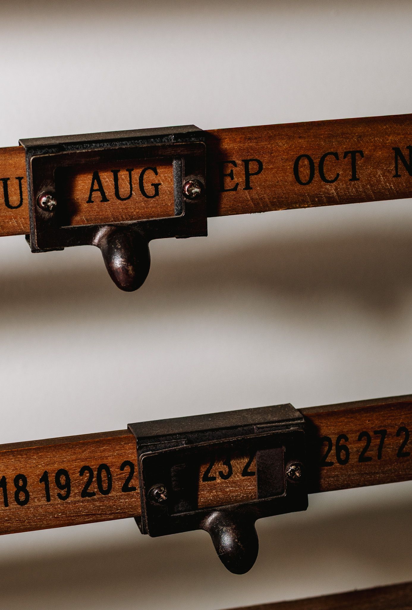 Vintage wooden perpetual calendar with engraved month and date markers on rustic display.