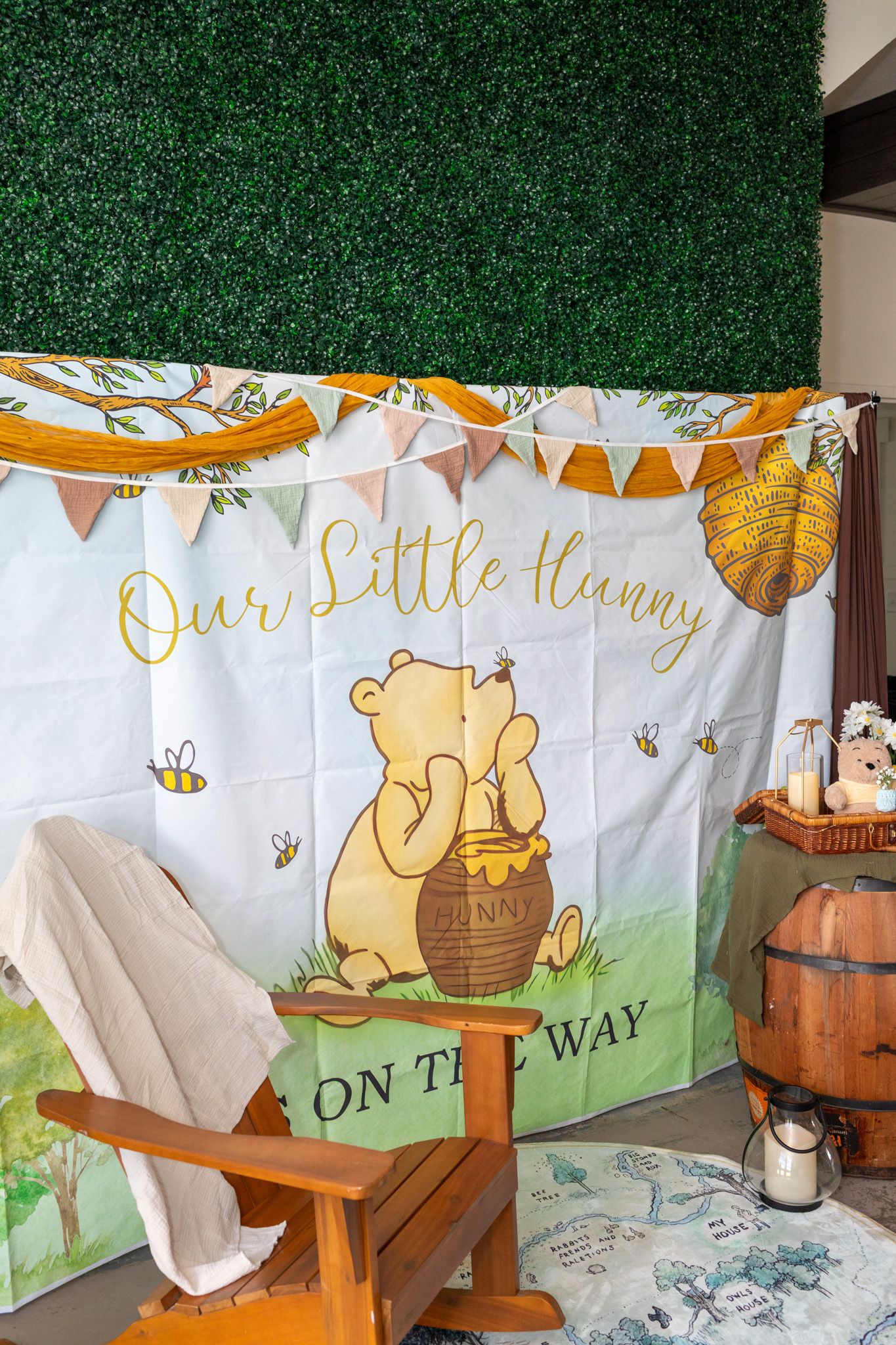 Winnie the Pooh baby shower backdrop reading Our Little Hunny On The Way with wooden chair.