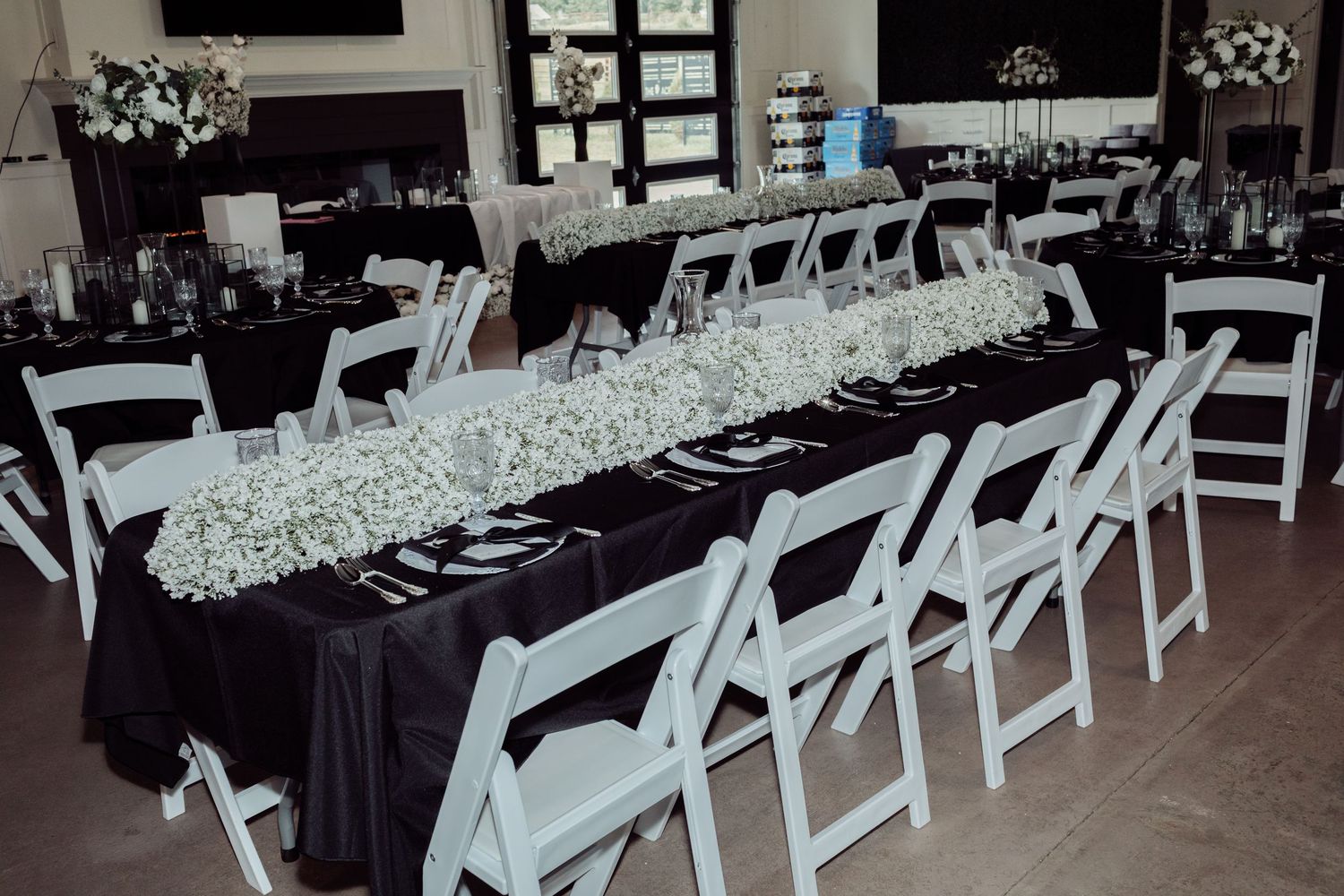 Elegant black and white wedding reception tables with baby's breath floral runners.