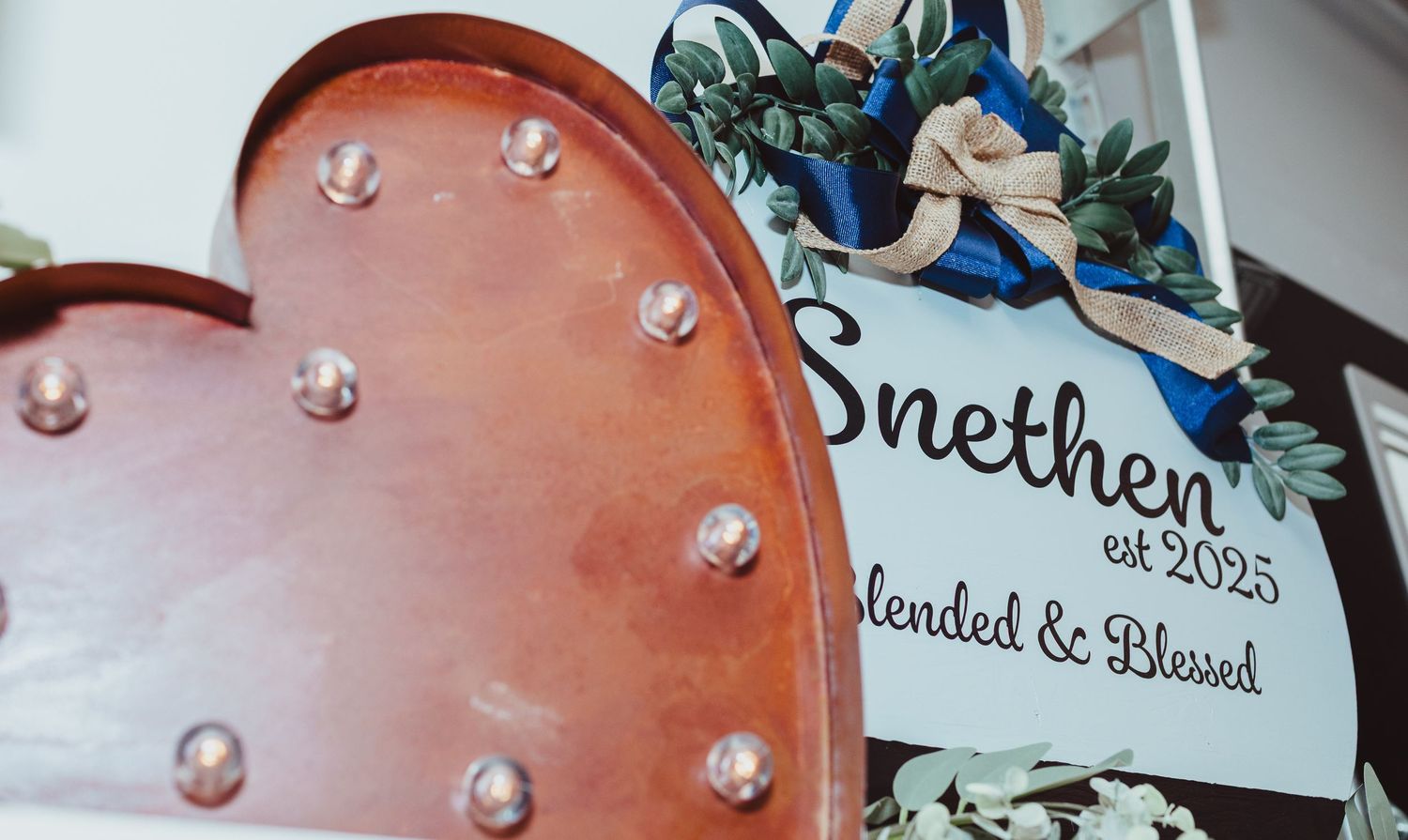 Rustic marquee light-up heart beside Snethen est 2025 Blended and Blessed wedding sign.